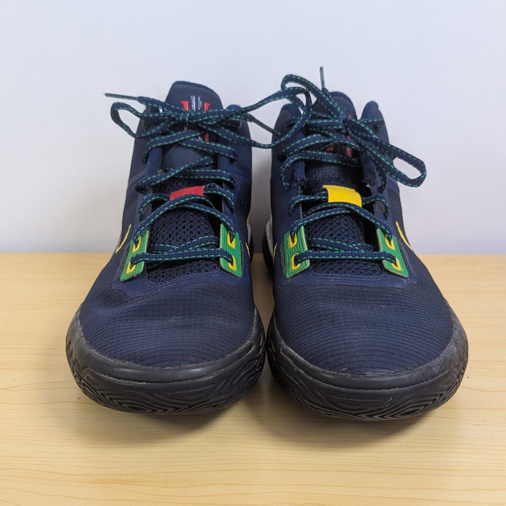 Pair of navy blue shoes with colorful accents on a wooden surface.